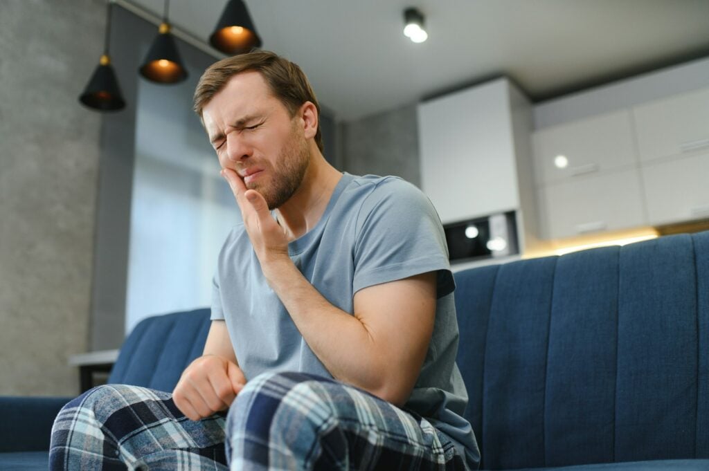 Person holding their cheek where an orthodontic wire is poking