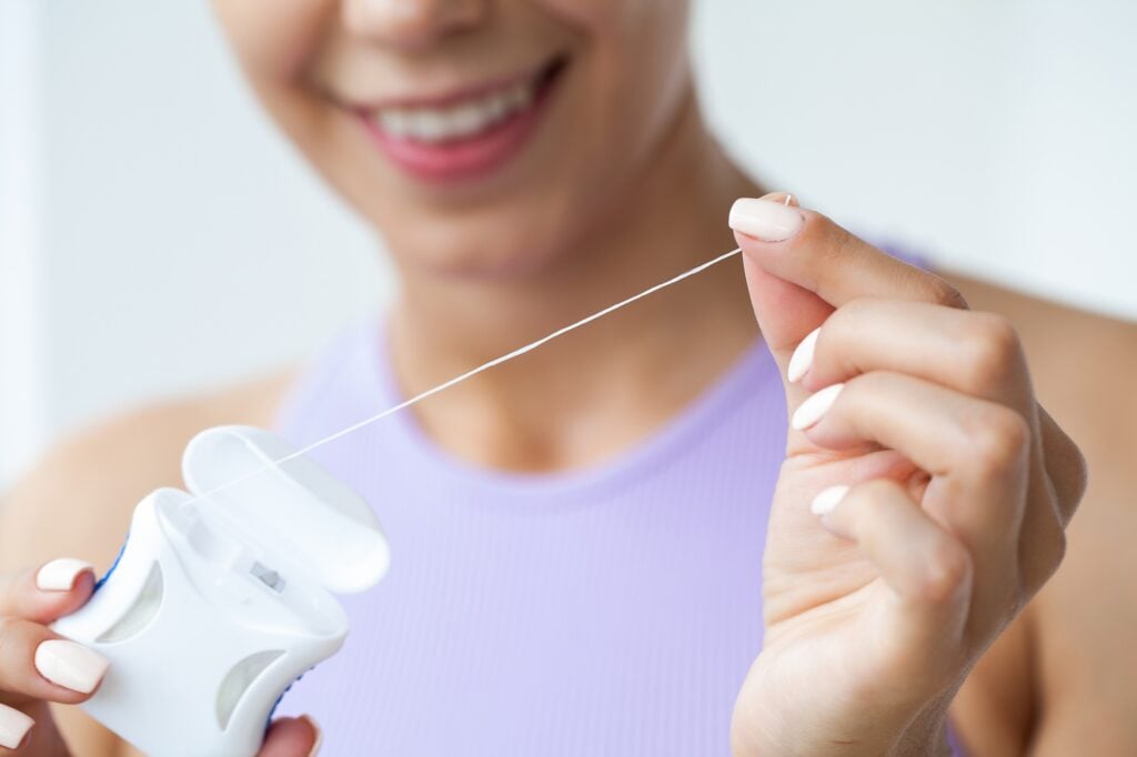Woman flossing between her teeth
